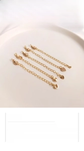 Five 14K gold plated extender chains with lobster clasps and unique charm pendants