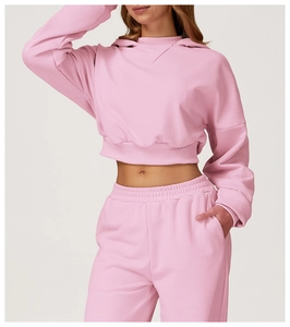Detail of pink cropped hoodie and matching joggers with soft cotton texture and ribbed cuffs