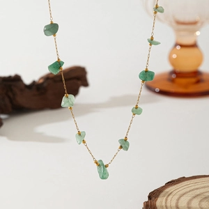 Detail of light green natural stone necklace with fine gold chain and small gold beads