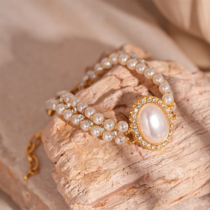 Détail du bracelet double rang en perles avec centre ovale en strass posé sur pierre