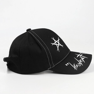 Detail of black cotton baseball cap with white star print and graffiti on the brim
