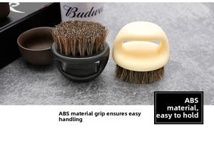 Close-up of circular ring beard brushes with ABS finger loop handles on a stone surface