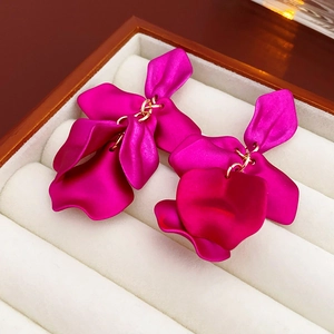 Gros plan de boucles d'oreilles pétales rouge rose dans un coffret à bijoux en velours