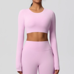 Détail du haut court de yoga rose à manches longues montrant la texture sans couture élastique