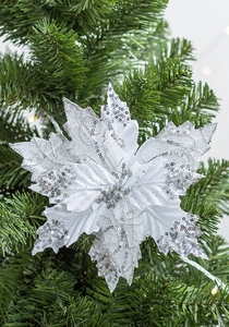 Détail d'un poinsettia artificiel blanc avec paillettes argentées sur sapin de Noël vert