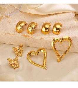 Detailed set of golden C-shaped, butterfly, and heart earrings on stone and silk