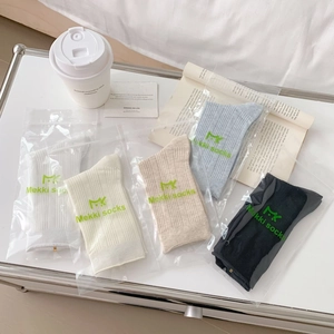 Minimalist breathable knit crew socks in five colors on a tray for daily wear