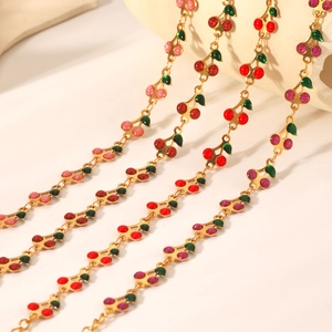Detailed close-up of cherry pendants with red enamel and glitter on golden chain