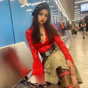 Dettaglio top in pizzo rosso con scollo a V, maniche a campana e gonna lunga vintage