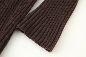 Gros plan sur la texture du tricot côtelé marron foncé montrant les détails des fibres