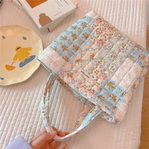 Detailed macro of the patchwork floral quilted cotton tote bag featuring the simple wish label