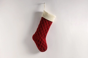 Detailaufnahme einer dunkelroten Strick-Weihnachtssocke mit Rautenmuster und weißem Saum