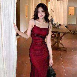 Detail of elegant dark red satin slip dress with slim fit design and draped texture