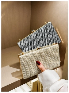 Detail of evening clutch bags with woven wave patterns, gold frames and crystal clasps