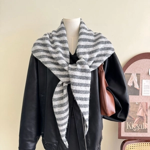 Close-up of grey and white striped wool knit triangle scarf on a black leather jacket