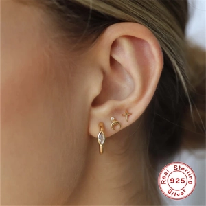 Detail of 925 sterling silver earring set with gold plating and zircon studs on model