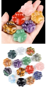 Detailed macro showing diverse amethyst and gemstone cat paw figurines held in hand