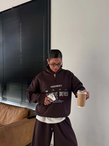 Détail de l'ensemble sweat marron à demi-zip avec imprimés lettrés en situation
