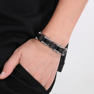 Macro detail of men's wide chain bracelet with silver and black carbon fiber textures