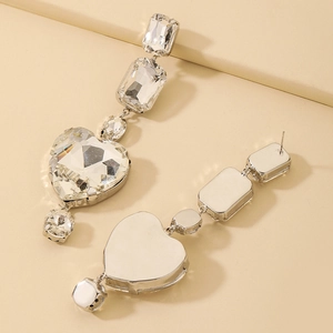 Detailed macro view of silver geometric long heart earrings with sparkling rhinestones