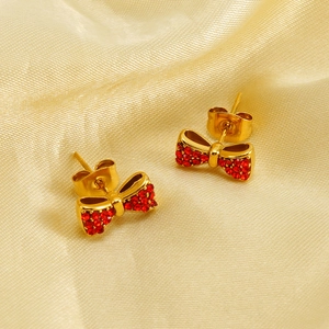 Boucles d'oreilles nœud plaquées or 18K avec cristaux rouges sur fond de soie