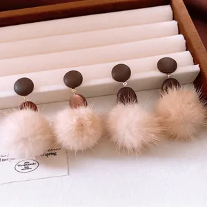 Winter vintage round pompom drop earrings with wood texture in a jewelry display box