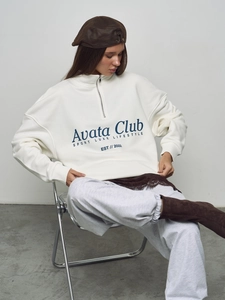Oversize white quarter-zip sweatshirt with blue letter print and relaxed aesthetic