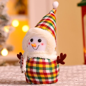 Christmas snowman plush doll decoration with red green plaid fabric and warm bokeh lights