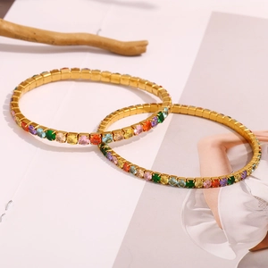 18K gold plated stainless steel bracelet with rainbow cubic zirconia on wood background