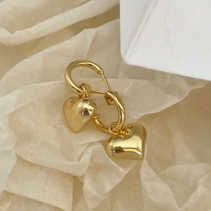 Minimalist 925 sterling silver gold heart dangle earrings on textured background