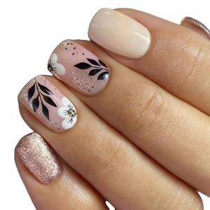 Short square press-on nails with white petals, black leaves, and rose gold glitter accents