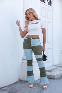Gros plan d'un jean flare à taille haute avec patchwork en denim vert et bleu ciel