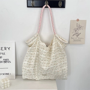 Dettaglio della borsa tote floreale in chiffon con manici rosa intrecciati e logo Sozakka