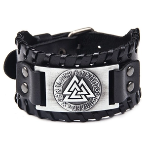 Close-up of black braided leather bracelet featuring a metal Valknut symbol and runic engraving