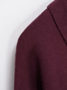 Close-up of deep burgundy knit polo shirt featuring ribbed collar and fine fabric texture