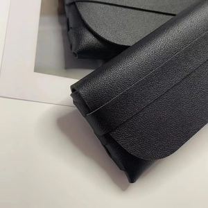Close-up of black lychee grain leather texture on minimalist slim glasses case