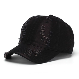 Detailed view of the ripped texture and distressed edges on a black denim baseball cap