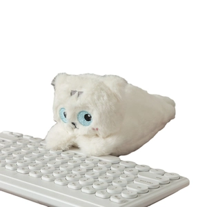 Cute white plush dog pencil case with large blue eyes lying on a white keyboard