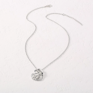 Detail of silver heart pendant with turtles and 'love you for always and forever' engraving