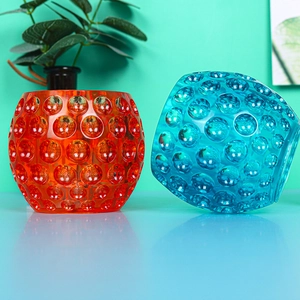 Artistic textured glass candle jars with colorful bubble pattern in blue and orange colors