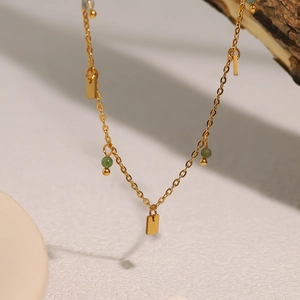 Bohemian gold necklace with irregular green stones and geometric rectangular charms