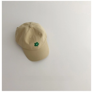 Détail de la casquette beige en coton pour enfant avec une broderie fleurie verte