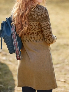 Outdoor back view of a long-sleeved dress with ethnic floral prints in earthy tones
