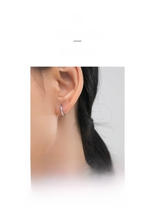 Close-up of minimalist S925 sterling silver hoop earrings with pavé zircon stones on a model