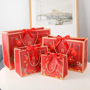 Red festive gift bags with 'Wishes' print and floral design in four varying sizes