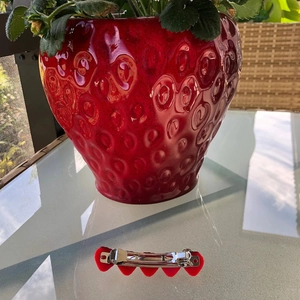 Detail showing a row of red resin hearts on a silver-tone metal hair clip design