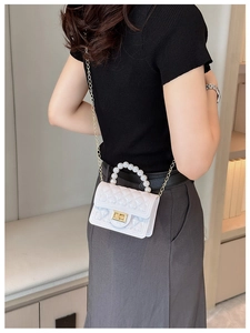 Elegant white pearl handle crossbody bag with quilted texture and golden metal lock detail
