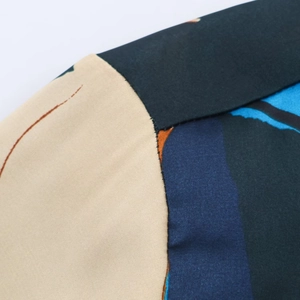 Macro detail of multi-color block stitching and fabric texture on a casual print shirt