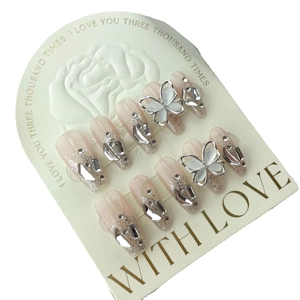 Handmade light pink gradient press-on nails with 3D white butterfly and silver glitter