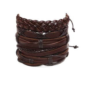 Macro detail of multi-layer hand-woven dark brown leather bracelets with rope textures